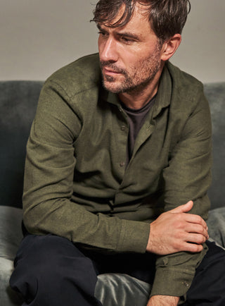 A long-sleeved green flannel shirt with a collar, button-up front, and a regular fit.

